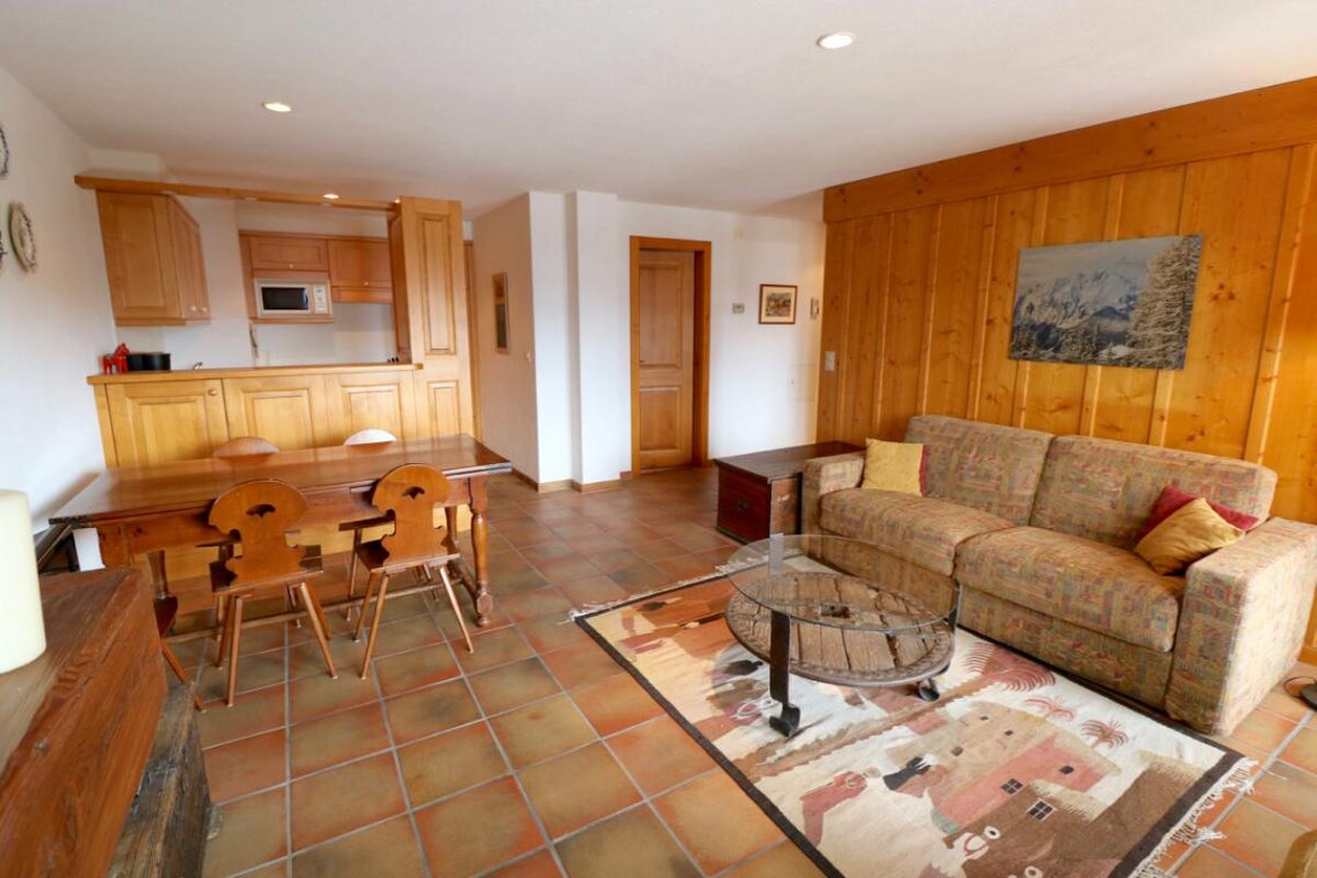A living room with a couch a table and chairs