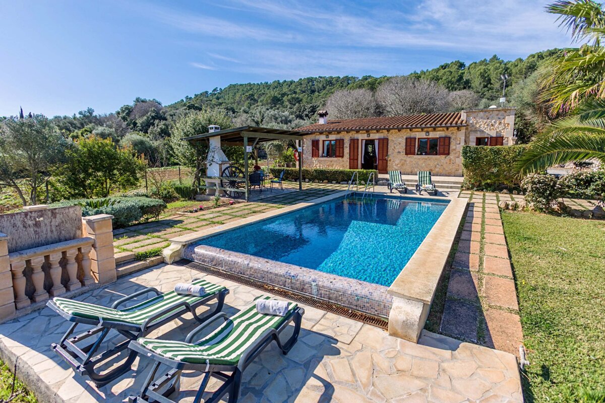 A house with a large swimming pool in front of it