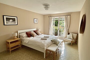 A bedroom with a large bed and a chair