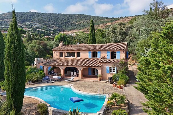 A large house with a large swimming pool in front of it