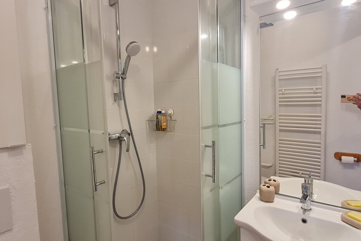 A bathroom with a shower and a towel rack