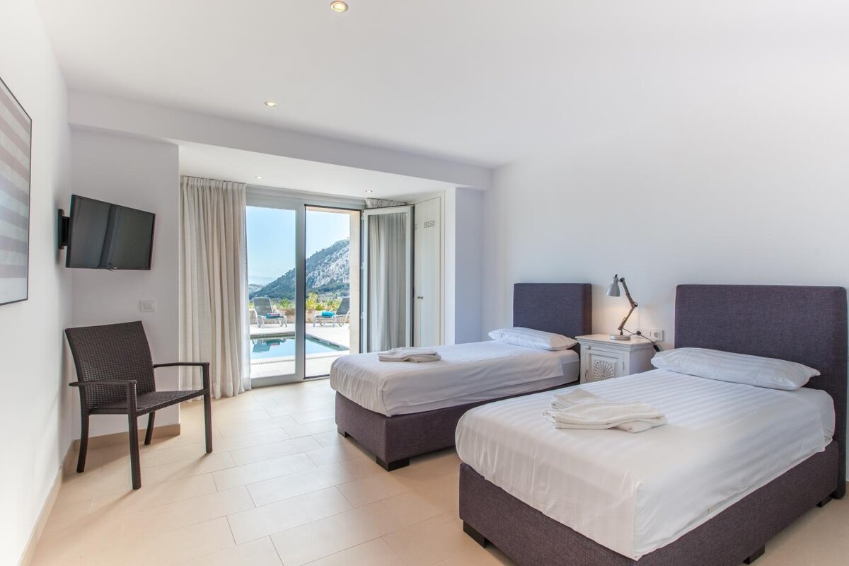 A bedroom with two twin beds and a flat screen tv