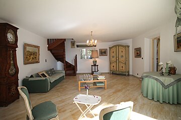 A living room with a clock and a staircase