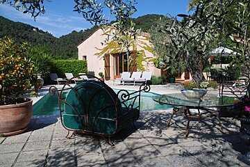 A swimming pool with chairs and a table in front of it