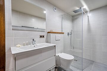 A bathroom with a toilet a sink and a mirror