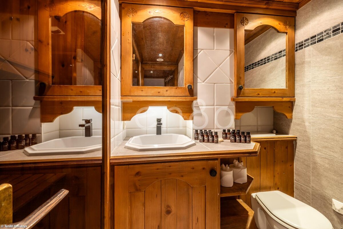 A bathroom with wooden cabinets and a toilet