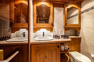 A bathroom with wooden cabinets and a toilet