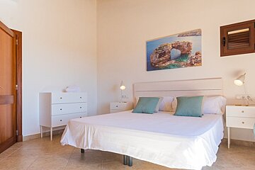 A bedroom with a bed and a picture on the wall