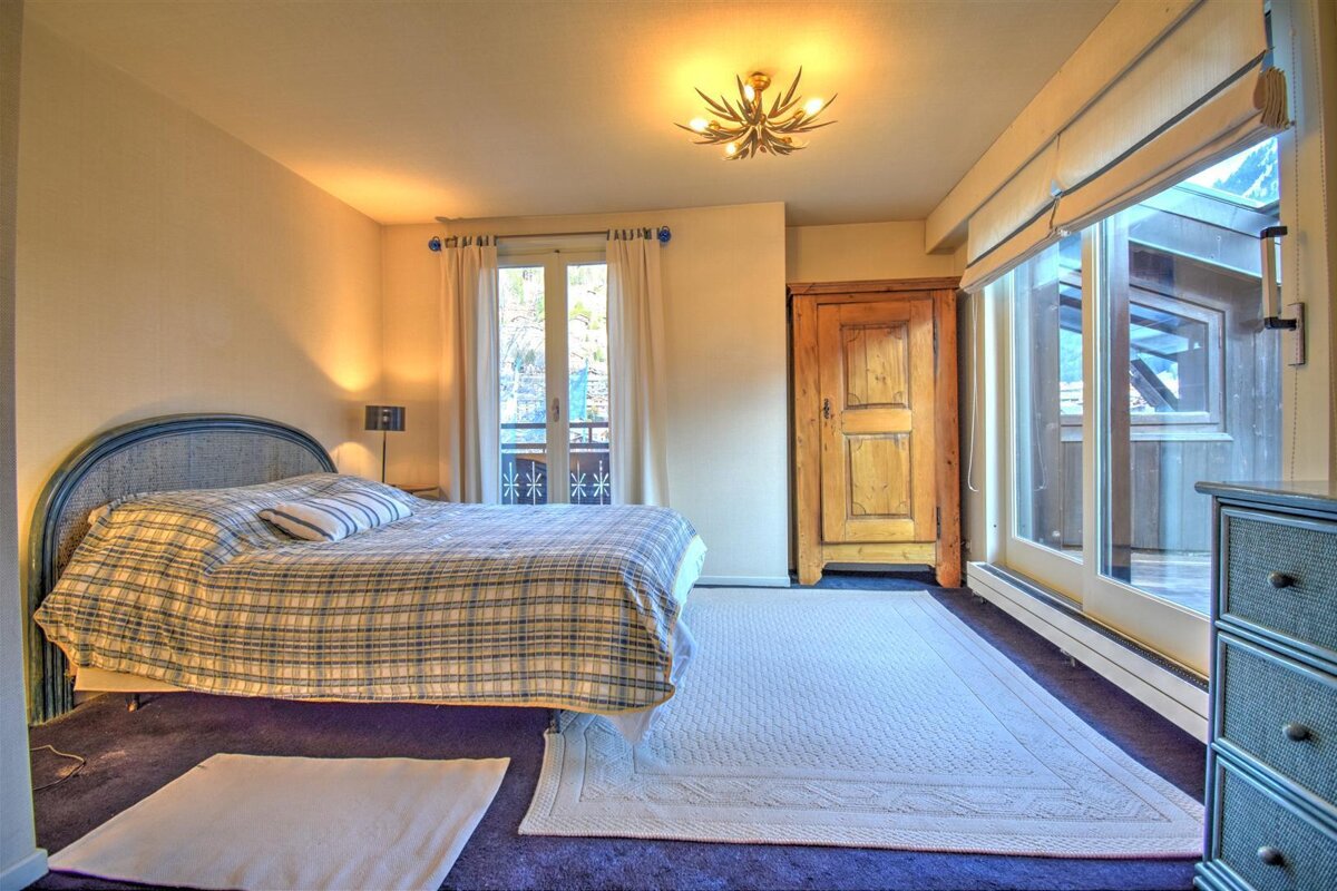 A bedroom with a large bed and a dresser