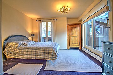 A bedroom with a large bed and a dresser