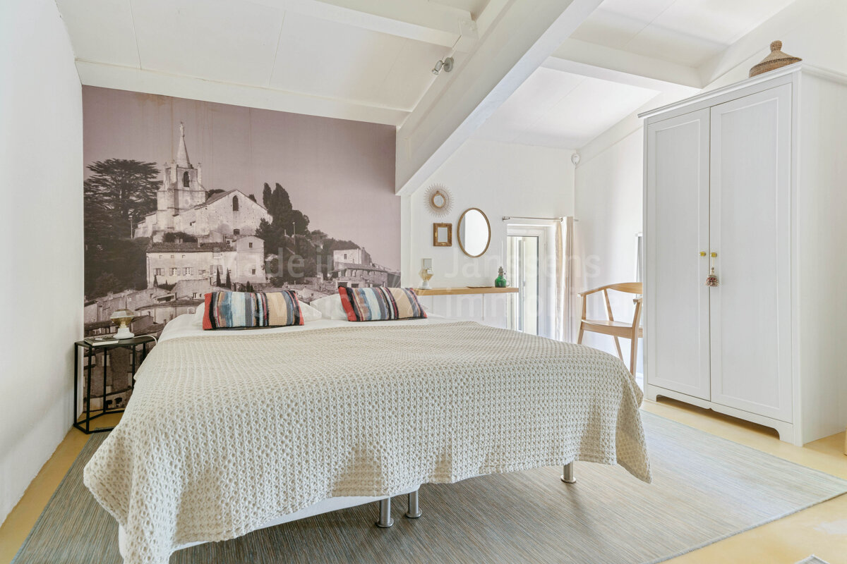 A bedroom with a large picture of a church on the wall