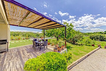 A patio with a table and chairs under a pergola