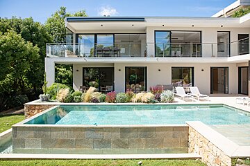 A large house with a large swimming pool in front of it