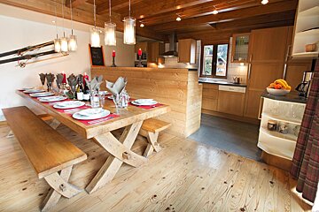 A wooden table with plates and utensils on it in a kitchen