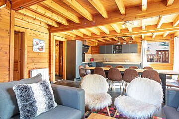 A living room with a couch and chairs and a dining table