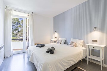 A bedroom with two beds and striped wallpaper