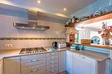 A kitchen with white cabinets and a stove top oven