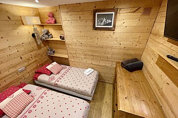 A bedroom with two beds and a picture on the wall