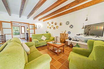 A living room with green furniture and a flat screen tv
