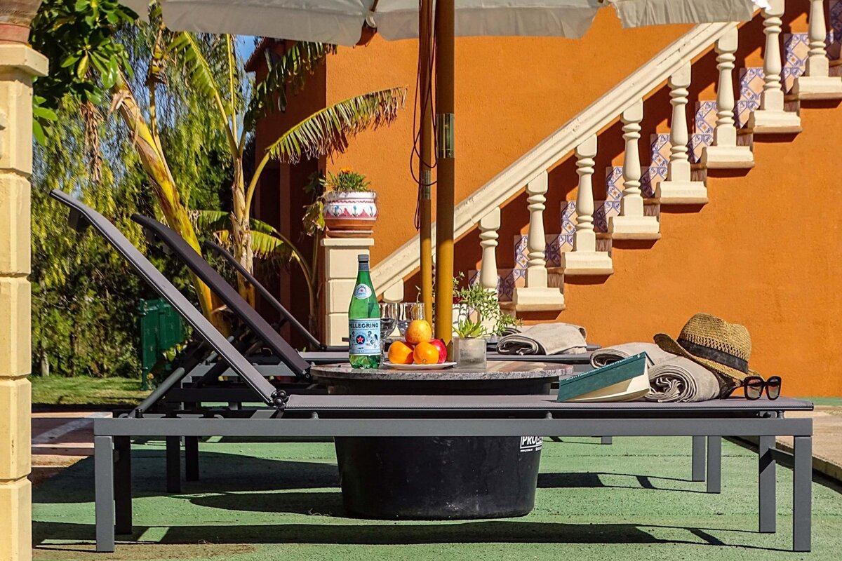 A bottle of pellegrino sits on a table under an umbrella