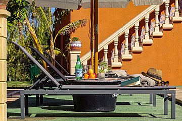 A bottle of pellegrino sits on a table under an umbrella