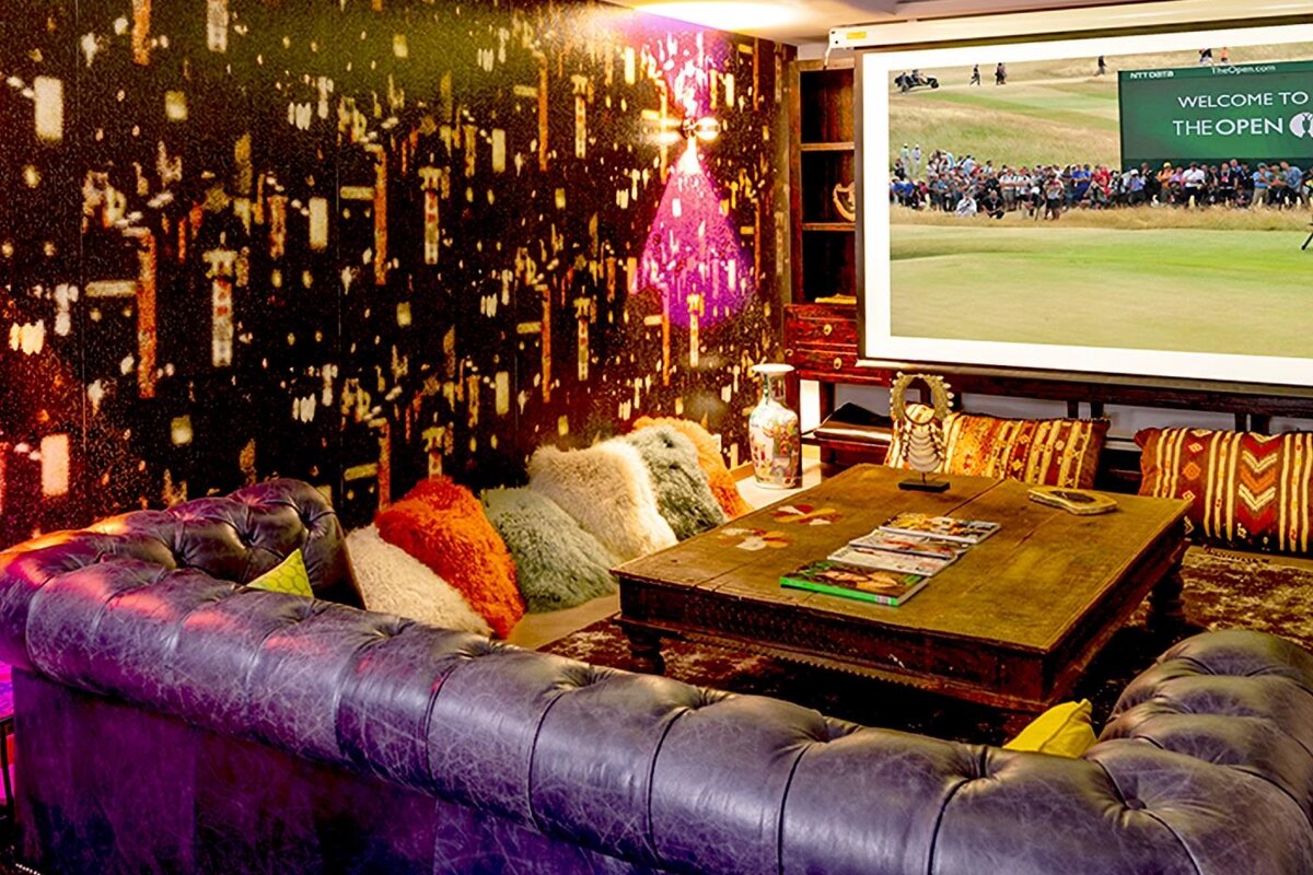 A room with a projector screen that says welcome to the golf