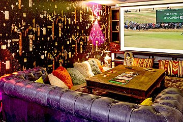 A room with a projector screen that says welcome to the golf