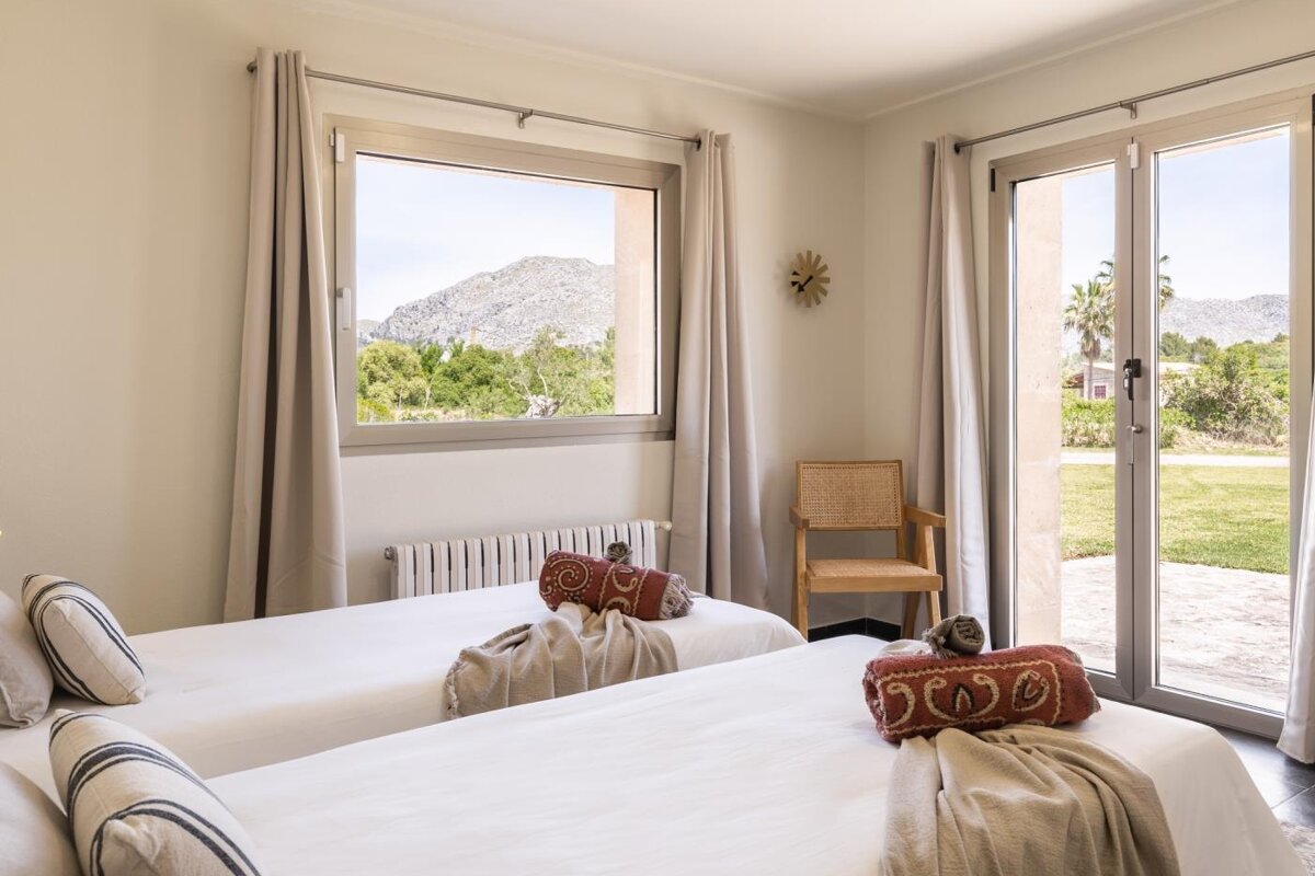 A bedroom with two beds and a clock on the wall