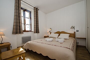 A small bedroom with a bed and a window