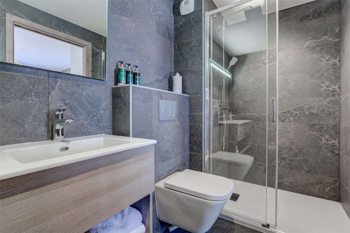 A bathroom with a toilet a sink and a mirror