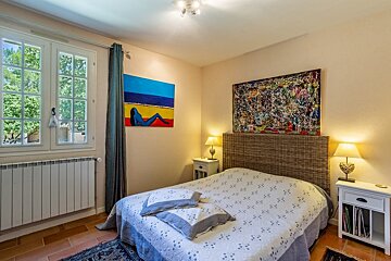 A bedroom with a bed and a painting on the wall