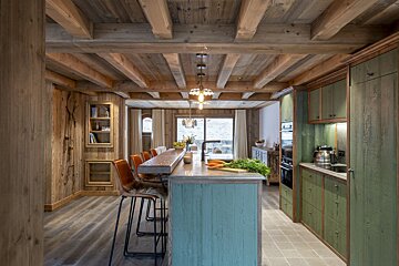 A kitchen with green cabinets and a wooden ceiling