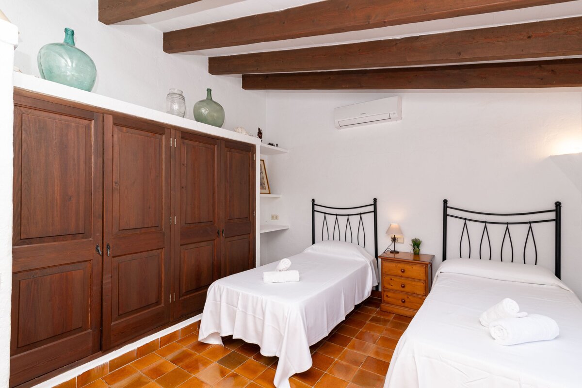 A bedroom with two beds and a nightstand