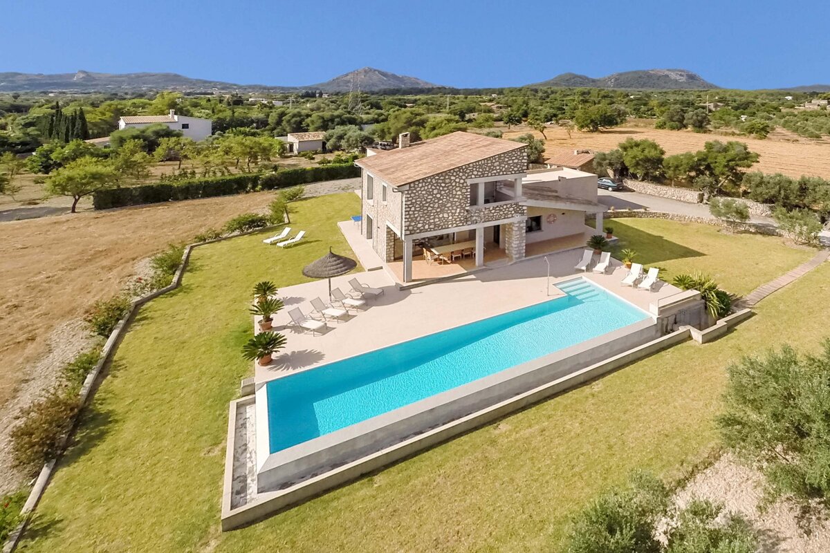An aerial view of a house with a large swimming pool