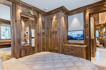 A bedroom with wood paneling and a flat screen tv
