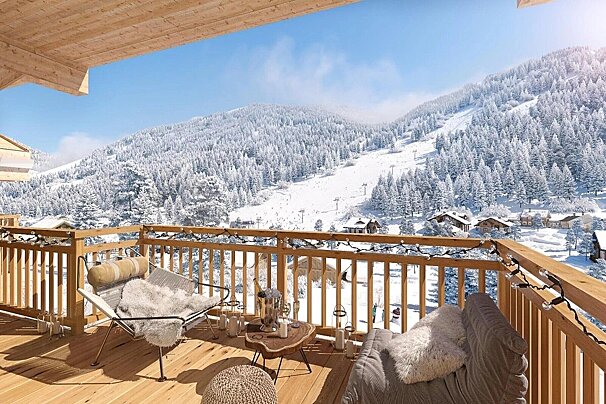A cozy balcony with string lights and plush seating overlooks a stunning, snow-covered mountain ski resort, pine forests, and village chalets.