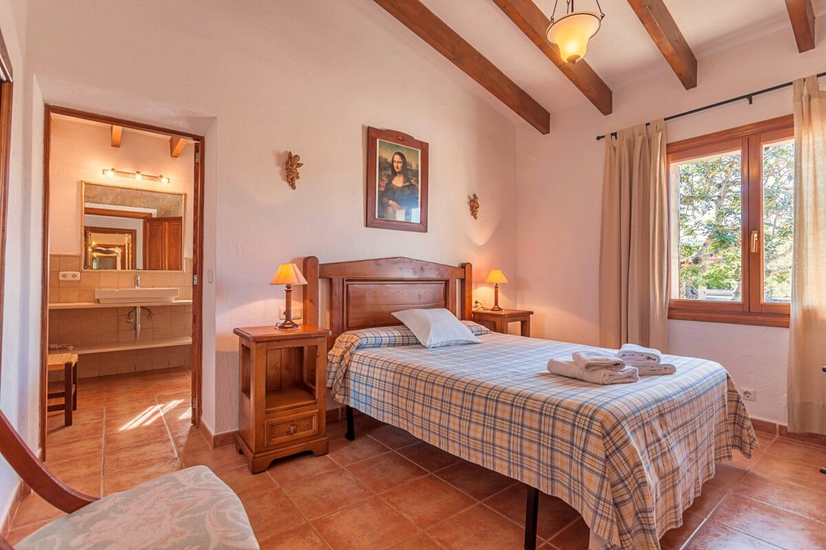 A bedroom with a bed and a painting on the wall