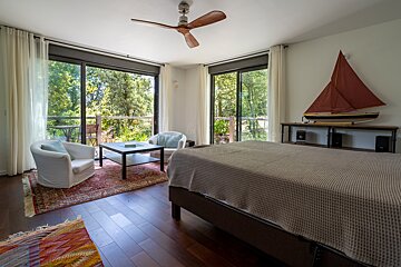 A bedroom with a boat on the wall above the bed