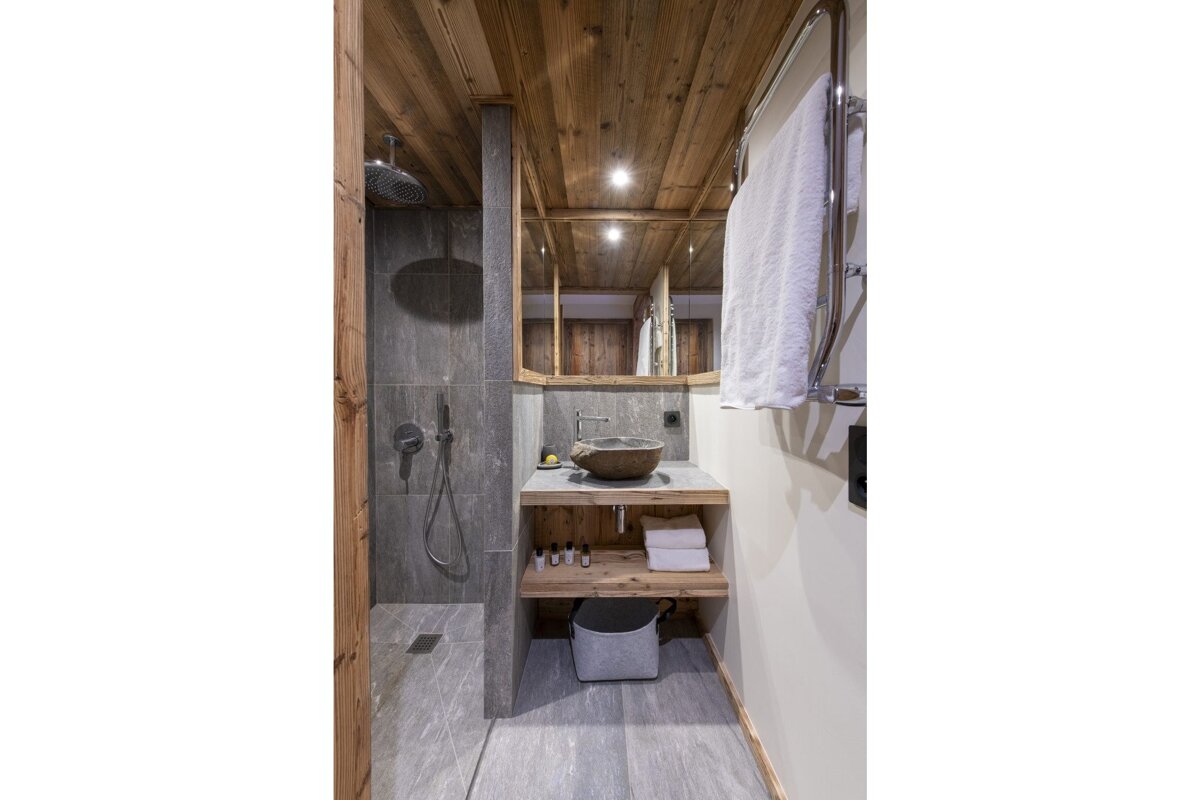 A bathroom with a sink and a walk in shower