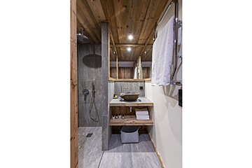A bathroom with a sink and a walk in shower