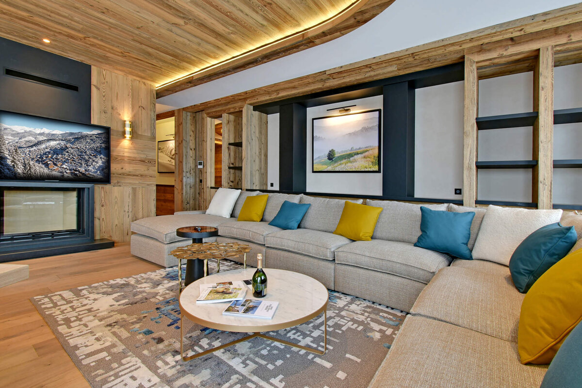 A living room with a large sectional couch and a round coffee table