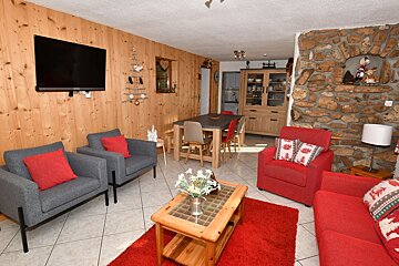 A living room with a couch and chairs and a flat screen tv