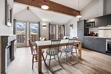 A kitchen with a table and chairs in it