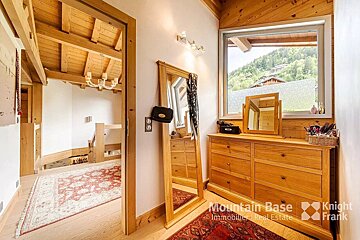 A room with a dresser and a mirror and the words mountain base knight frank on the bottom