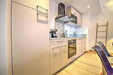 A kitchen with white cabinets and stainless steel appliances