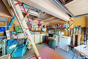 A room with a ladder and skis that say rossignol on them