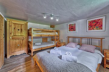 A bedroom with a bunk bed and a king size bed
