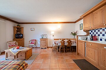 A living room with a table and chairs and a flat screen tv