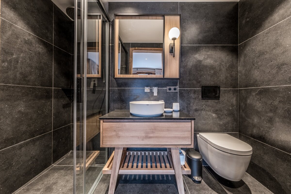 A bathroom with a toilet a sink and a mirror