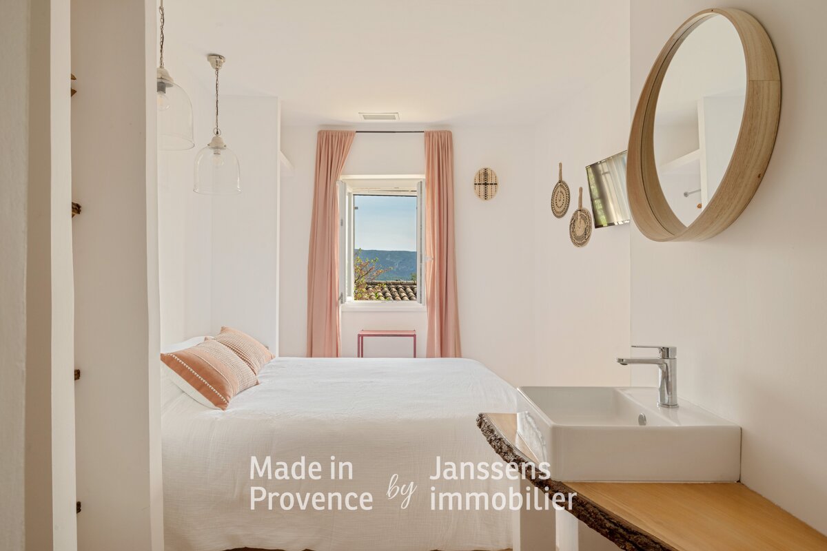 A bedroom with a bed and a sink made in provence by immobilier
